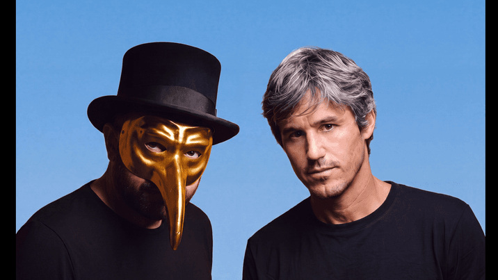 Claptone in his gold mask and top hat beside his collaborator