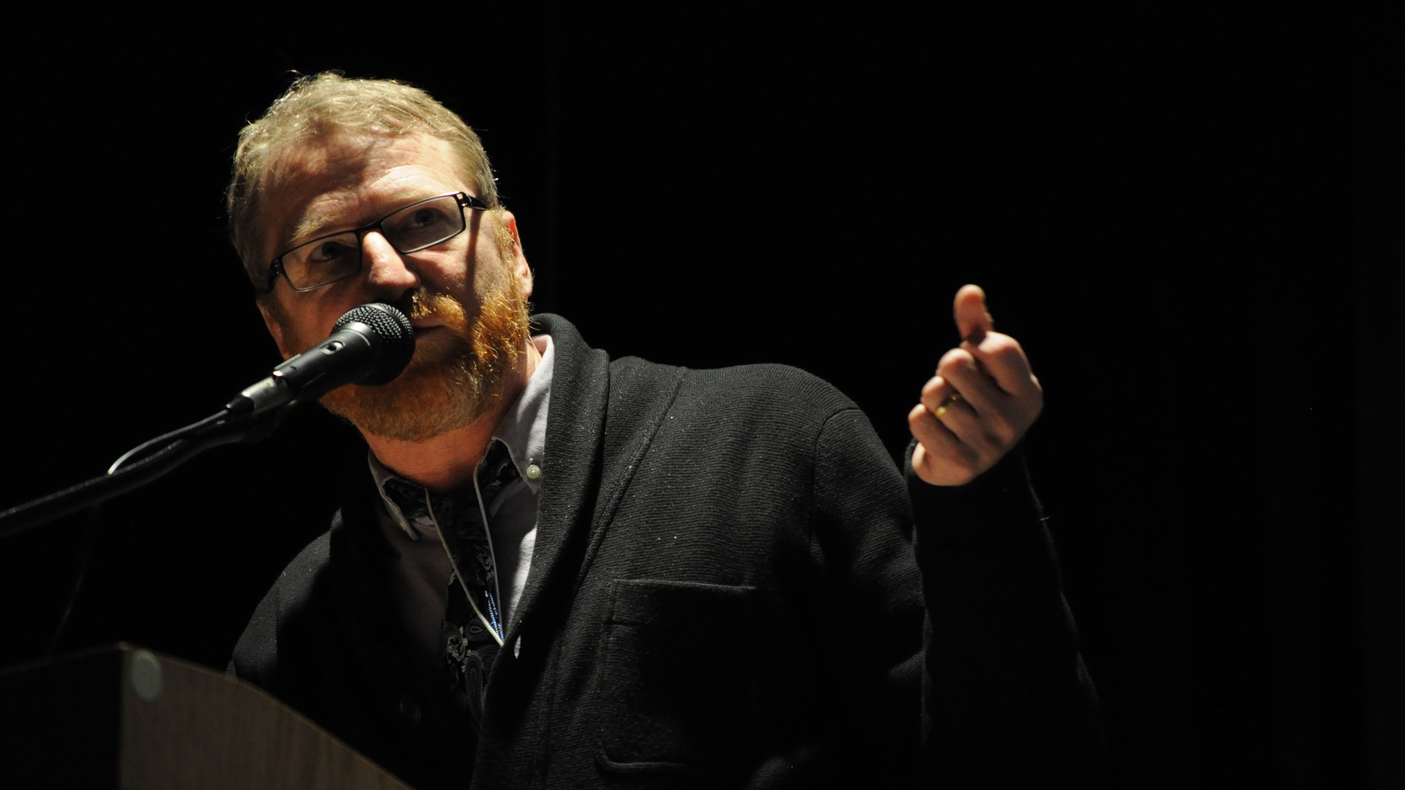 David Lowery derrière un pupitre, devant un microphone