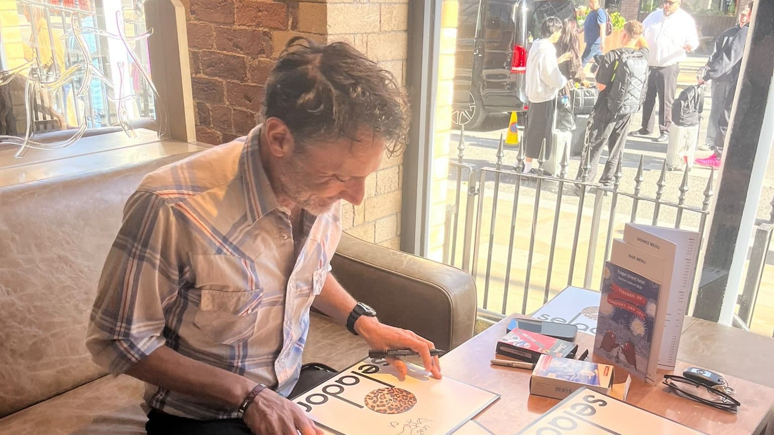 Danny Howells signiert an einem Tisch Vinylplatten von Selador